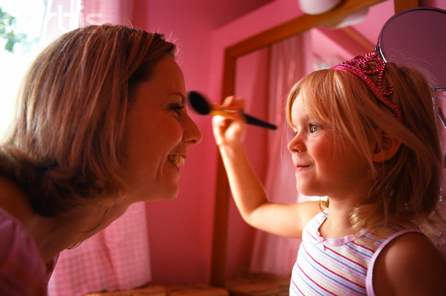 Little Girl Putting Make-Up on Woman's Face